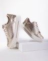 Stylowe, złote sneakersy damskie Caprice ze skóry naturalnej o metalicznym wykończeniu. Ażurkowa cholewka i system AIRMOTION dbają o optymalną wentylację oraz wyrazisty wygląd. Wygodny i modny wybór do miejskich stylizacji.